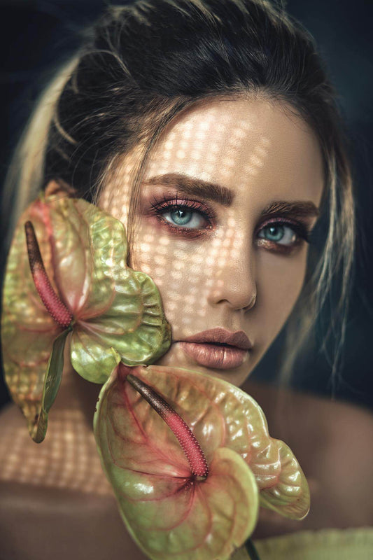 Woman’s face behind a green leaf – symbolising plant exosomes and natural skin rejuvenation