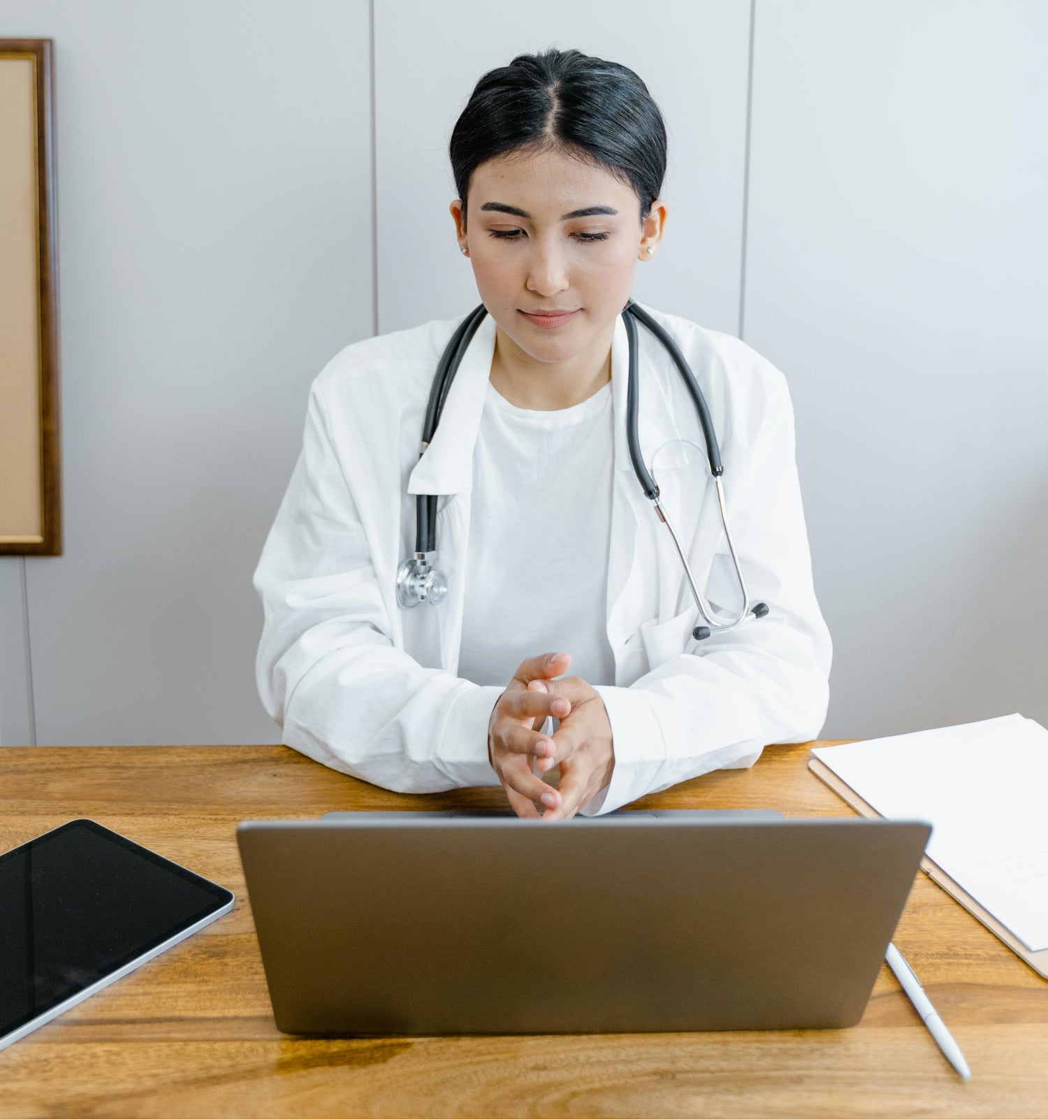 Female doctor looks at laptop