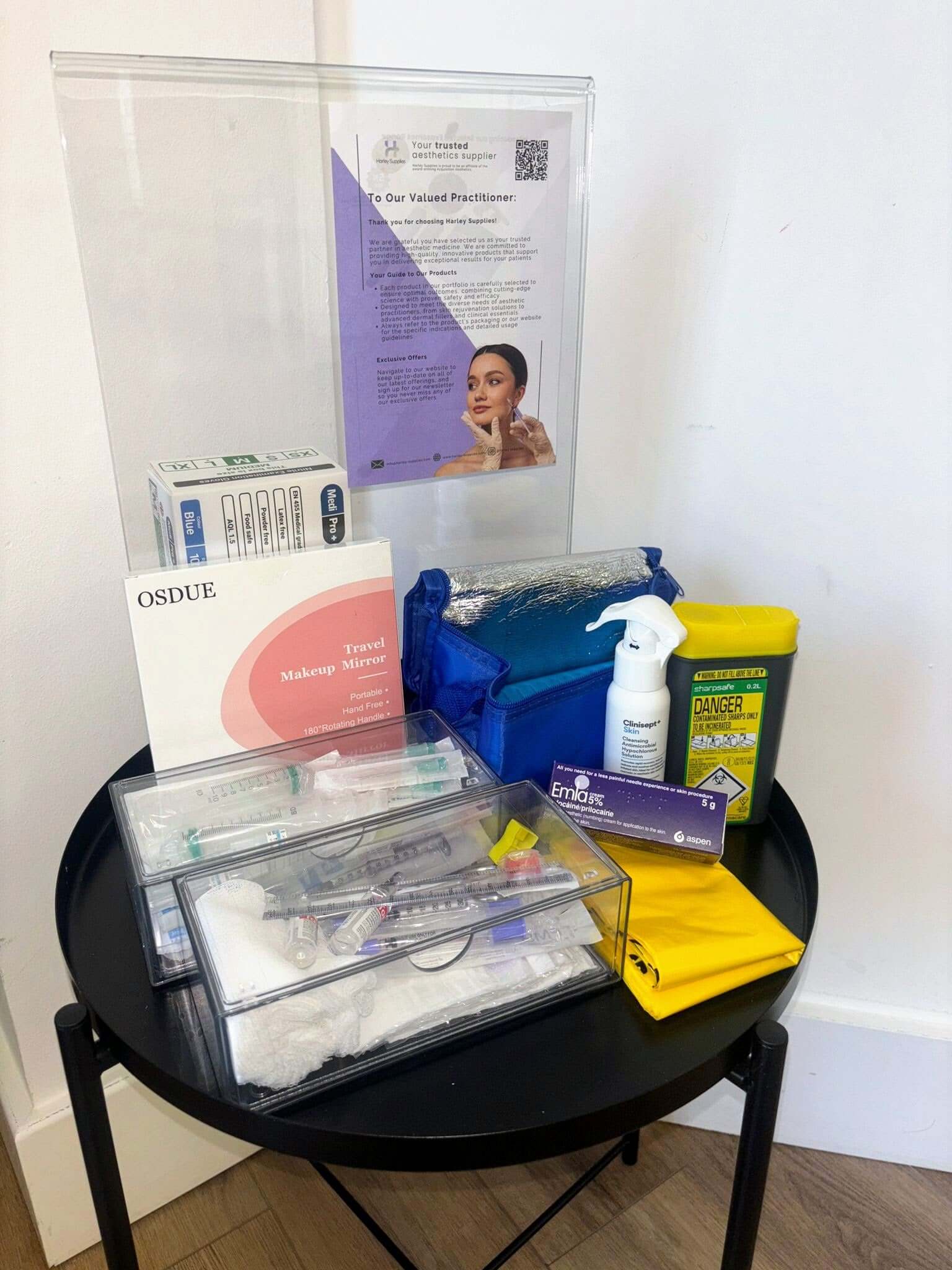 Medical supplies including syringes, bandages, and a box on a round black table.