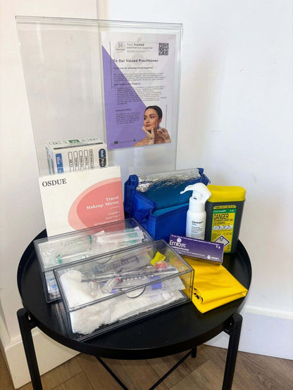 Medical supplies including syringes, bandages, and a box on a round black table.